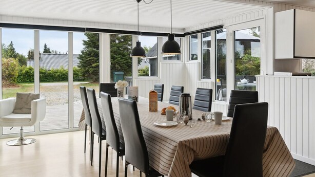 A modern dining area with a long table, black chairs, and pendant lighting. - "Hallveig" - 1.1km from the sea by Interhome (Væggerløse)