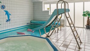 An indoor swimming pool with a slide, a ladder, and a jacuzzi. - "Hallveig" - 1.1km from the sea by Interhome (Væggerløse)