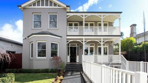 A two-story house with a balcony, a covered porch, and a front door. - Inner City Resort  (St Kilda)