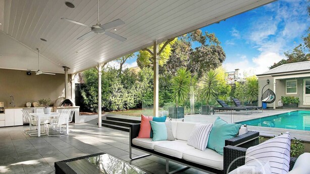 A covered outdoor patio with a pool, seating area, and kitchen. - Inner City Resort  (St Kilda)