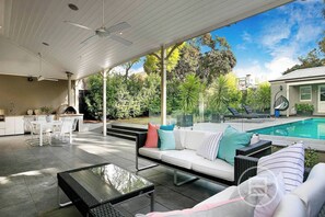 A covered outdoor patio with a pool, seating area, and kitchen. - Inner City Resort (St Kilda)
