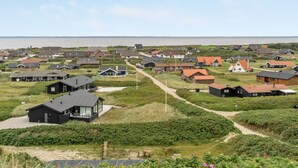 Een kustdorp met huizen, een heldere lucht en uitzicht op de zee.