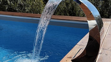 Una piscina al aire libre de temporada, sombrillas