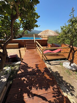 Una piscina al aire libre de temporada, sombrillas