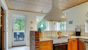 Une cuisine moderne dotée d’un îlot central, de meubles en bois et d’un four encastré.