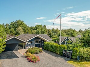 A residential property with a house, a flagpole, and surrounding greenery. - "Maureen" - 10.5km from the sea by Interhome (Oksbøl)