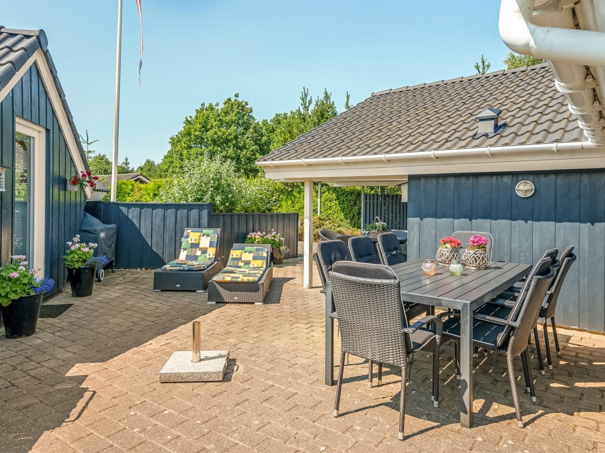 A patio with outdoor furniture, a covered seating area, and a fenced backyard.