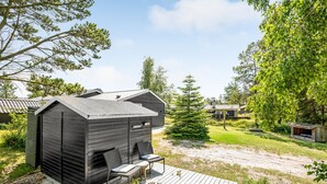 A modern cabin with a wooden deck, a fireplace, and outdoor seating. - "Riekje" - 2.3km from the sea by Interhome (Rømø)