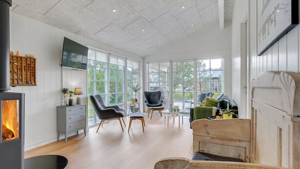 A spacious living room with a fireplace, large windows, and modern furniture. - "Riekje" - 2.3km from the sea by Interhome (Rømø)