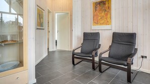 A modern interior with two dark chairs, a glass display case, and a wooden-paneled wall with a painting. - "Lima" - 3.5km from the sea by Interhome (Rømø)