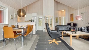 A modern interior with a dining area, a black leather sofa, and a kitchen in the background. - "Lima" - 3.5km from the sea by Interhome (Rømø)