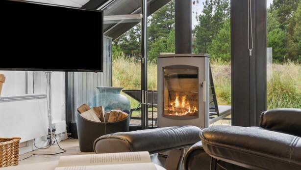Een moderne woonkamer met een open haard, comfortabele zithoek en een televisie.
