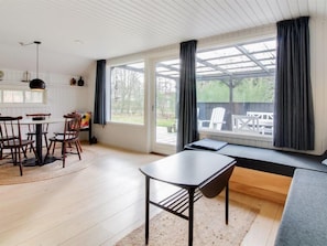 Relax in a spacious room with a dining area, seating area, and large window offering a view of the outdoors.