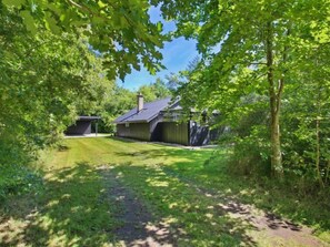 Escape to a serene retreat surrounded by lush greenery and trees, with a peaceful atmosphere perfect for relaxation.