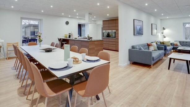 A modern, open-plan living space with a dining area, kitchen, and seating area.
