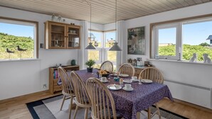 A dining area with a wooden table, chairs, and a view of birds outside. - "Tedora" - 300m from the sea by Interhome (Fanø)