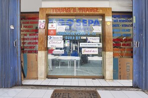 Entrada de una agencia de viajes, con logotipos de varias aerolíneas y un felpudo de bienvenida.