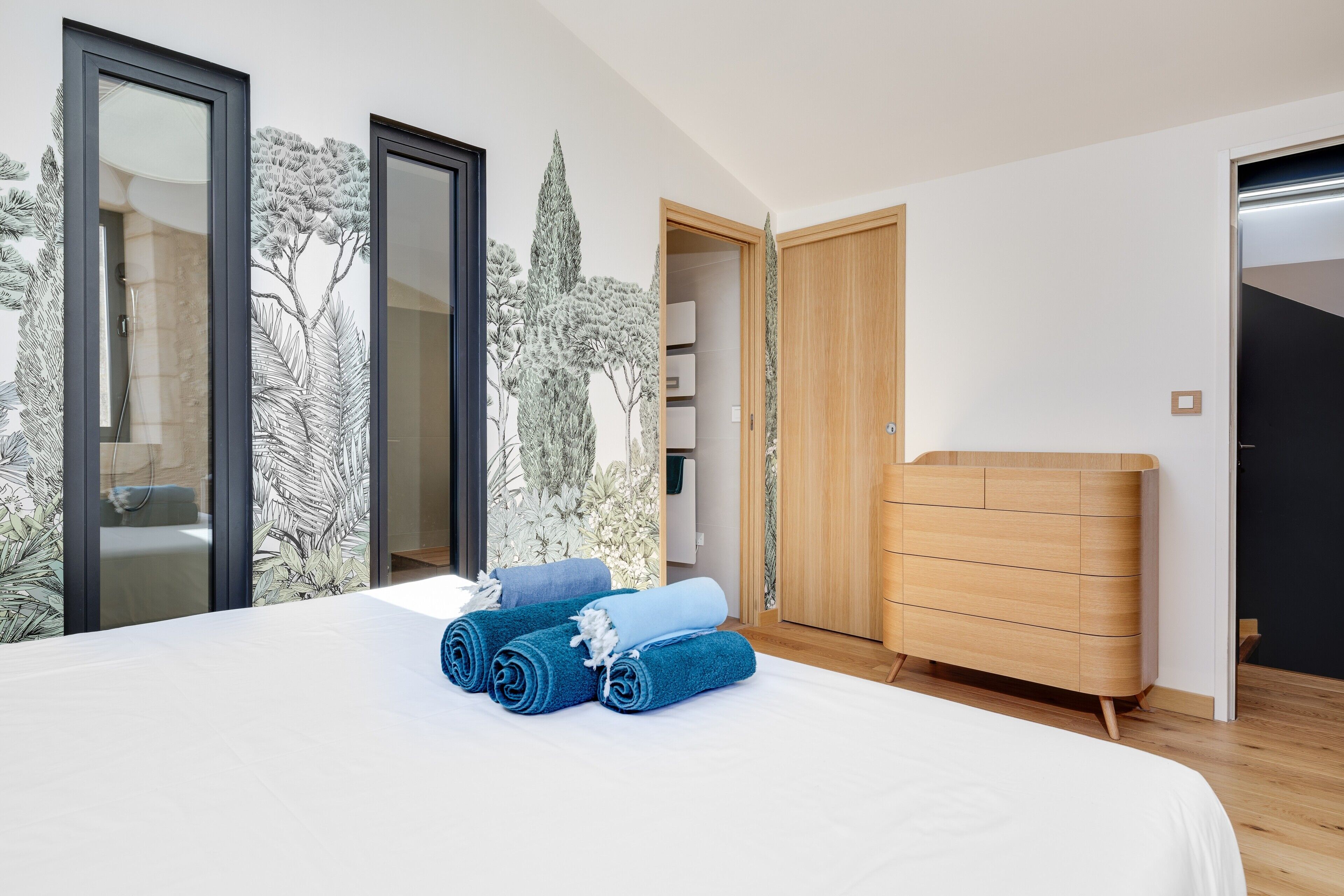 Une chambre à coucher avec un lit, une commode en bois et une armoire.