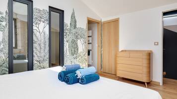Une chambre à coucher avec un lit, une commode en bois et une armoire.