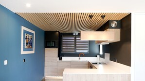 Eine moderne Küche mit Holzbalkendecke, Spüle und Arbeitsplatte.