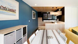 Ein modernes Interieur mit Esstisch, Stühlen, einer Couch und einer Küchenzeile.