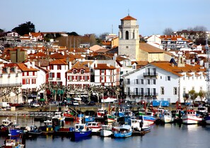 Ein Hafen mit Booten, einem markanten Turm und bunten Gebäuden.