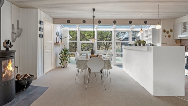 A modern kitchen with a central island, a dining area with chairs, and a fireplace. - "Andine" - 1.2km from the sea by Interhome (Fanø)