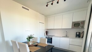 A modern kitchen with white cabinets, a microwave, and a coffee maker. - Apartment "Sunny Panorama" with Sea View, Shared Pool & Wi-Fi (Torrox)