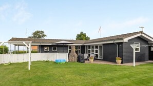 Een huis met een overdekte patio, een stenen openhaard en het nummer 20 op de deur.