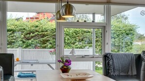 Een gezellig zithoekje met een tafel, stoelen en uitzicht op groen.