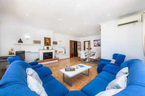 Ein Wohnzimmer mit blauen Sofas, einem weißen Couchtisch und einem Kamin.