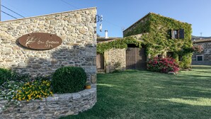 Un edificio de piedra con una placa que dice 'Casa Contada 1771' y un césped bien cuidado.
