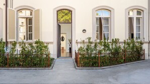 A building with three arched windows, a central door, and a small garden area with a fence. - Holiday Home 'Mirò' with Private Garden, Wi-Fi & Air Conditioning (NO ZTL) (Lucca)