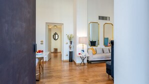 A modern living room with a sofa, a lamp, and a mirror. - Holiday Home 'Mirò' with Private Garden, Wi-Fi & Air Conditioning (NO ZTL) (Lucca)