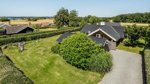 Un quartier résidentiel composé de plusieurs maisons, avec des pelouses bien entretenues et un grand arbre au premier plan.