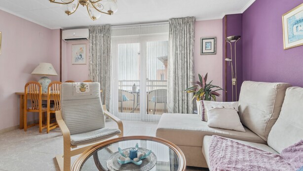 Un salon comprenant un canapé, un fauteuil, une table à manger et des chaises.