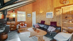 A cozy wooden interior with a fireplace, a sofa, a dining table, and a bookshelf. - "Simonia" - 600m from the sea by Interhome (Sydals)