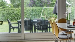 A dining area with a table and chairs, a swing set, and a garden view. - "Simonia" - 600m from the sea by Interhome (Sydals)