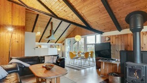 A cozy cabin interior with a living area, dining space, and a wood-burning stove. - "Simonia" - 600m from the sea by Interhome (Sydals)