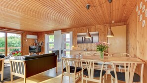 A wooden cabin interior with a dining area, a sofa, and a kitchen. - "Ellyn" - 500m from the sea by Interhome (Haderslev)