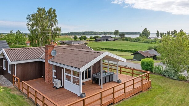A house with a deck, a covered patio, and a view of a lake. - "Ellyn" - 500m from the sea by Interhome (Haderslev)