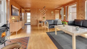 A cozy cabin interior with a wooden ceiling, a dining area, a sofa, and a fireplace. - "Ellyn" - 500m from the sea by Interhome (Haderslev)
