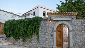 A stone wall with a wooden door and a light fixture above it.