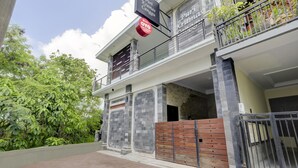 Un bâtiment à deux étages doté d’un balcon, d’une entrée fermée par un portail et d’une enseigne indiquant une vente.