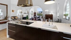 A spacious kitchen with a central island, dark wood cabinets, and pendant lighting.