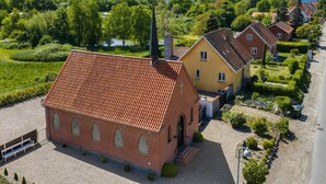 A residential area with a red-brick building, a yellow house, and a well-maintained garden.
