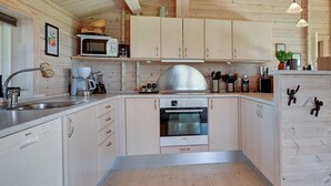 Una cocina moderna con armarios de madera, electrodomésticos de acero inoxidable y piso de madera.