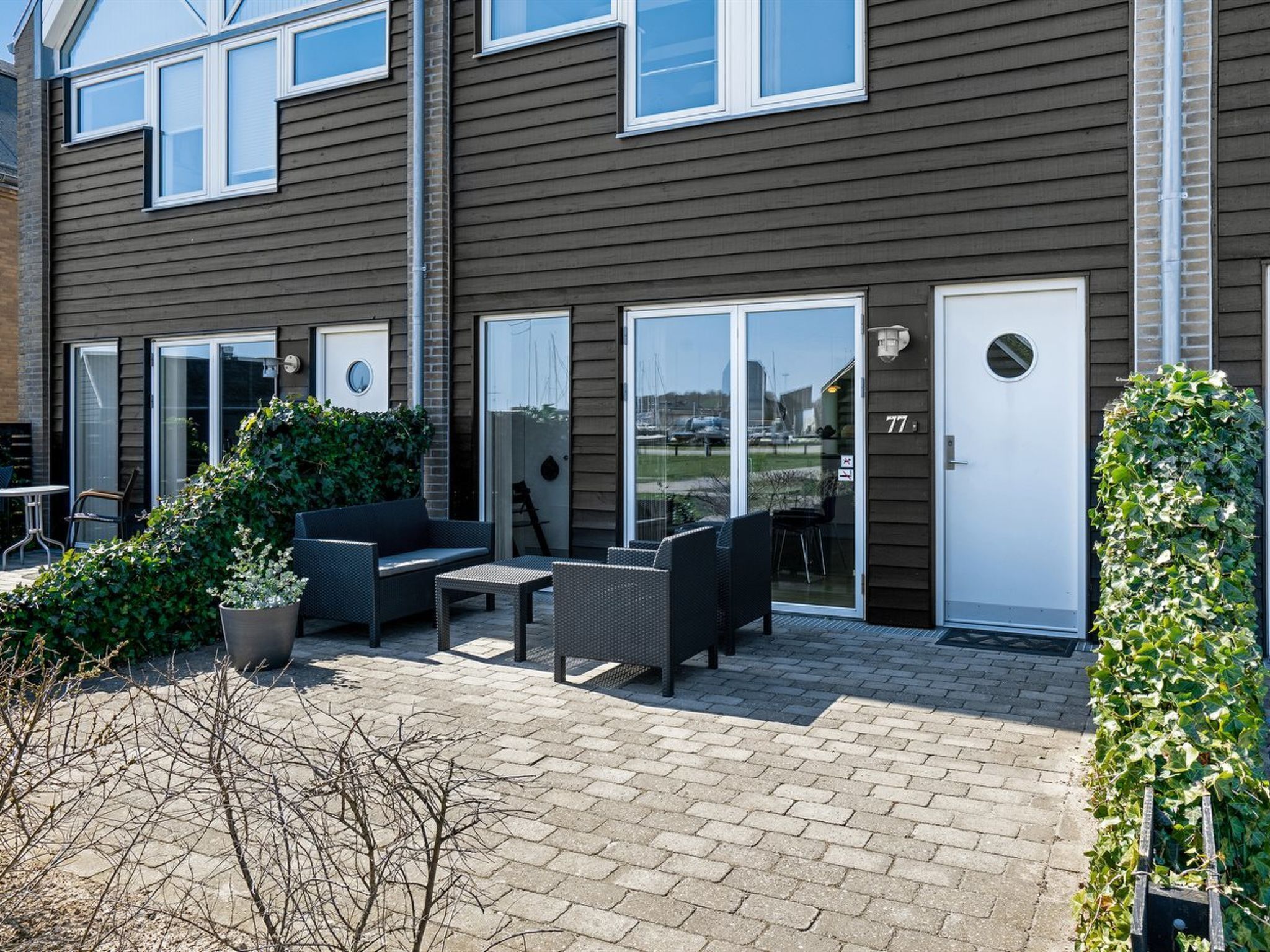 En moderne lejlighed med en patio og udendørs møbler, samt udsigt til gaden.