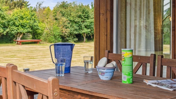 Ein Holztisch mit einer Kanne, Gläsern, einer Schüssel und einer Lebensmittelbüchse.
