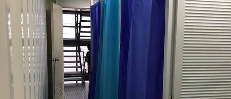 A corridor with a tiled floor and a series of blue curtains.